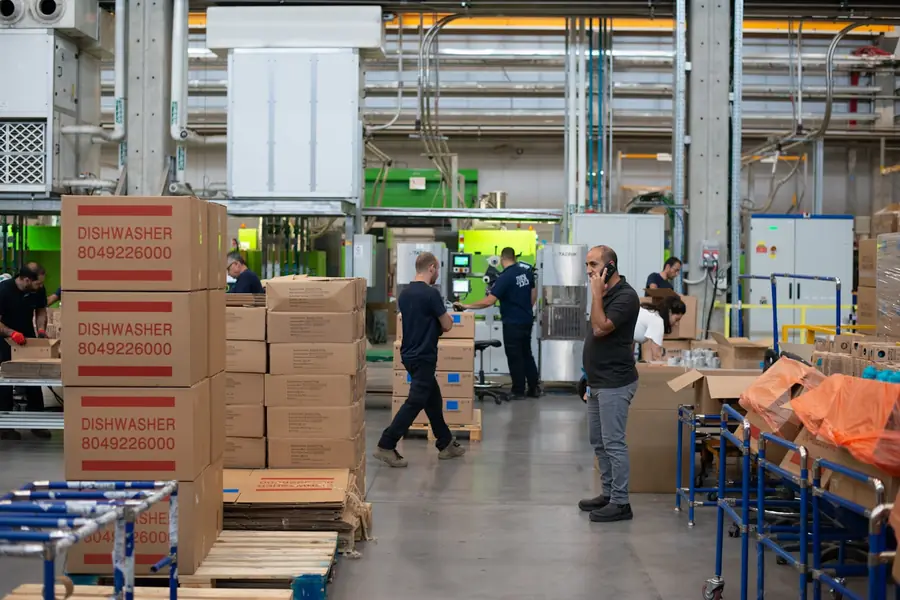 Goods and pallets being checked on a warehouse floor